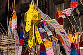 Chiang Mai - The Wat Phan Tao temple, small chedi shaped structures decorated with colorfull flags on the southern side wall of the Wihan 